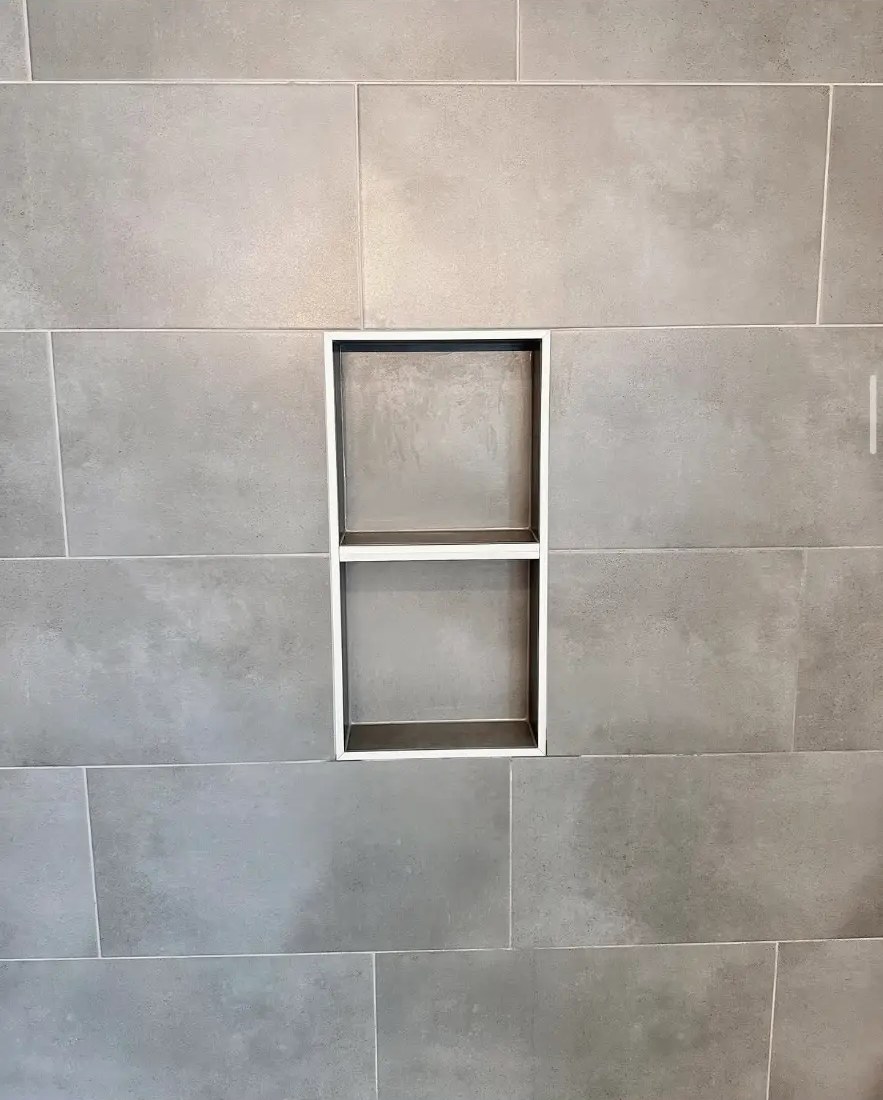 Built-in tiled shower niche detail in large-format concrete-look tile