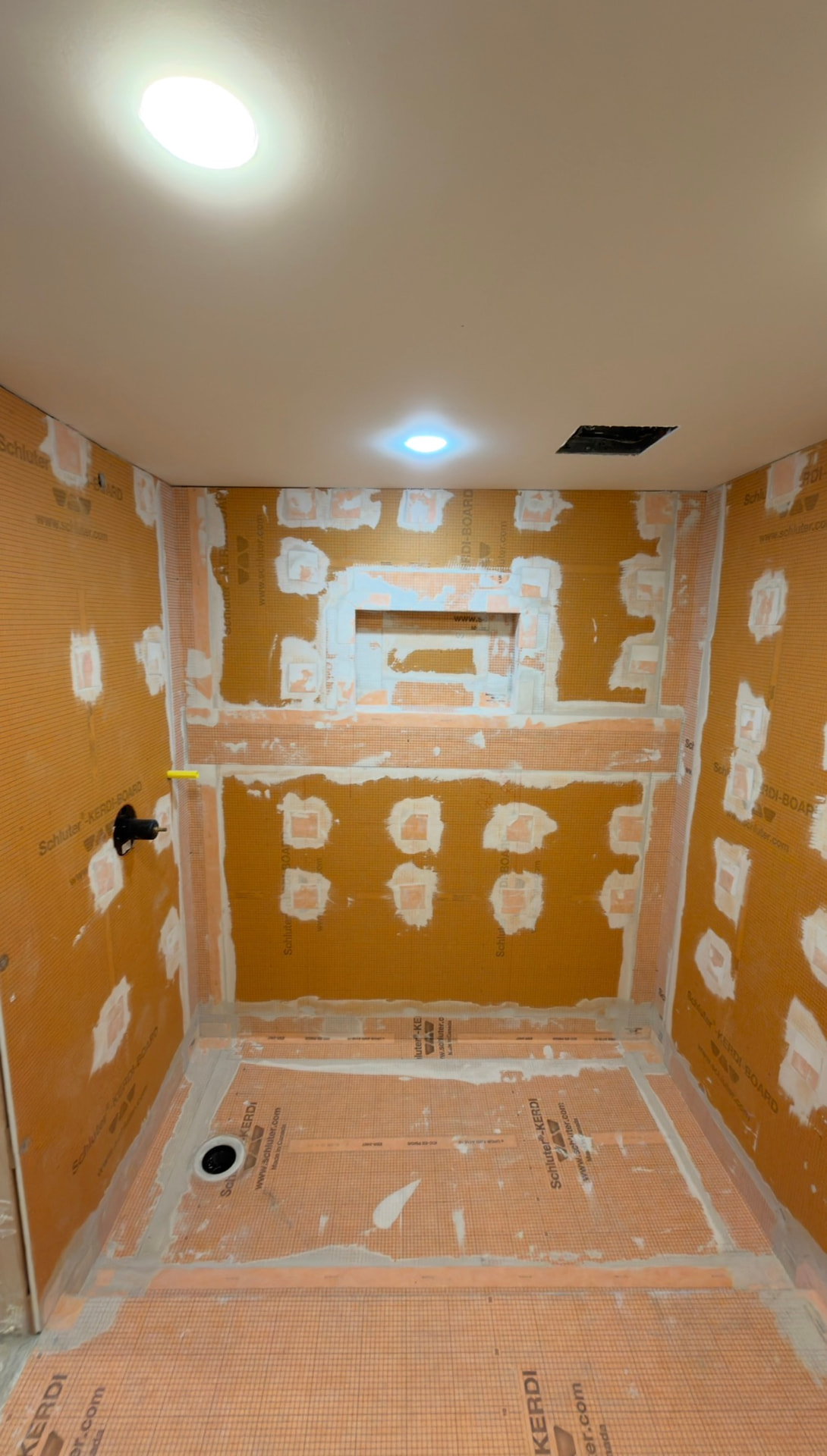 Waterproofed shower with a detailed niche, taped seams and bonded pan membrane