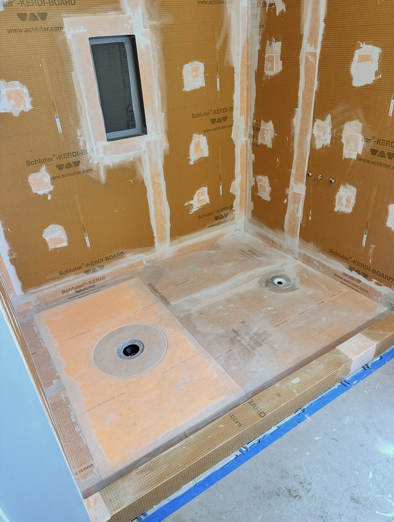 Double-drain waterproofed shower pan with the curb and corners fully detailed