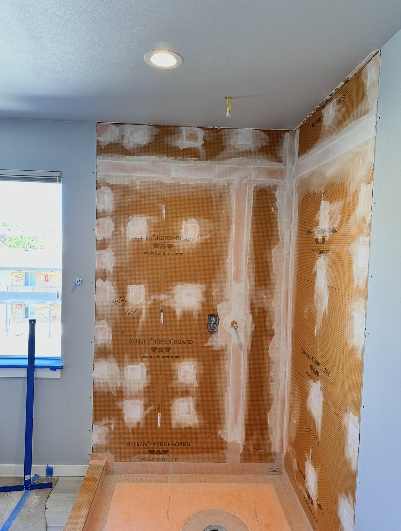 Shower walls sheeted in waterproof board with fasteners and seams sealed before tile