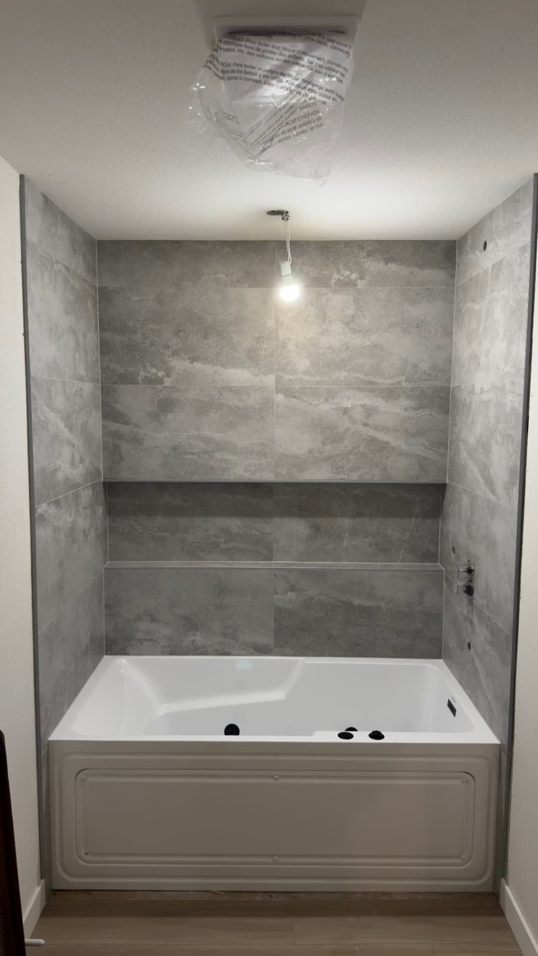 Large-format gray tile tub surround with recessed horizontal shelf in a primary bathroom in Kent, WA by BV Construction LLC