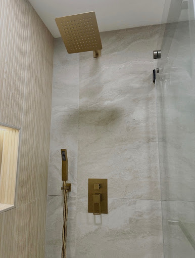 Walk-in shower with brushed gold rain head, hand shower and marble-look large-format tile