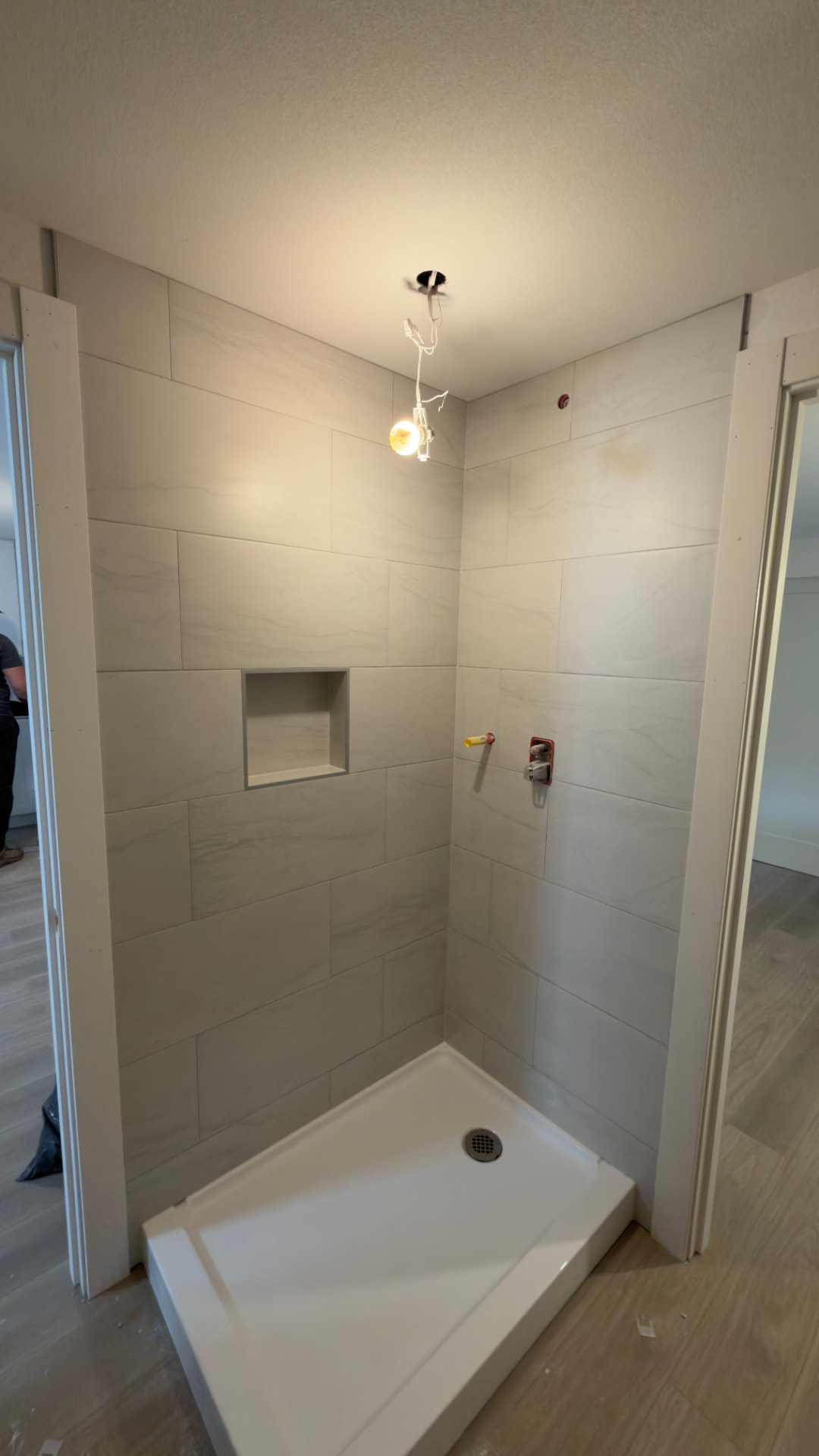 Large-format tile shower with recessed niche in a guest bathroom in Kent, WA by BV Construction LLC